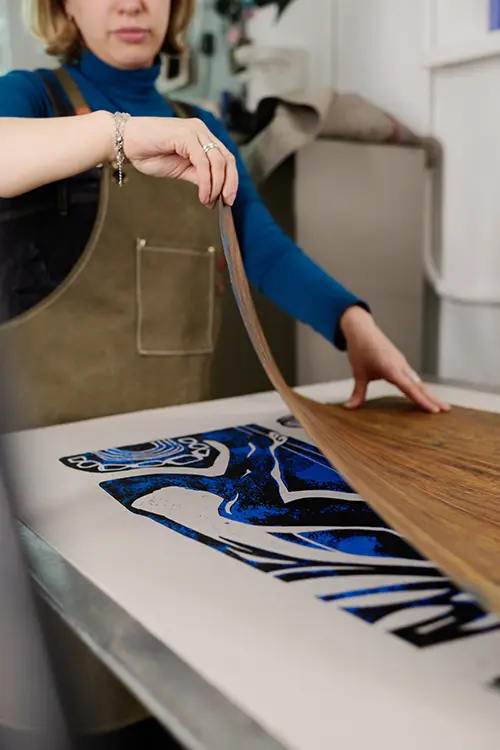 Operatrice che applica un transfer con stampa a caldo su una maglietta personalizzata