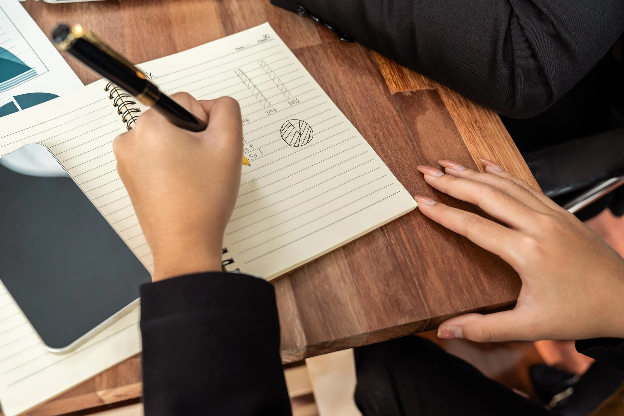 Scrittura a mano su agenda durante una riunione di lavoro