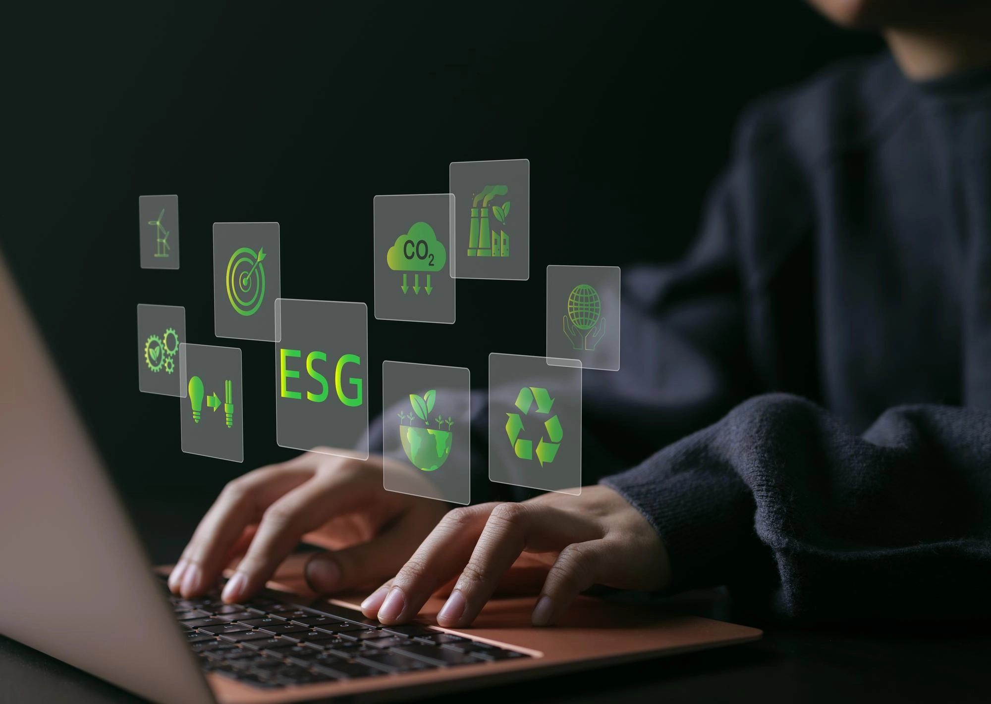 Persona digita al computer con icone ESG e sostenibilità ambientale in overlay