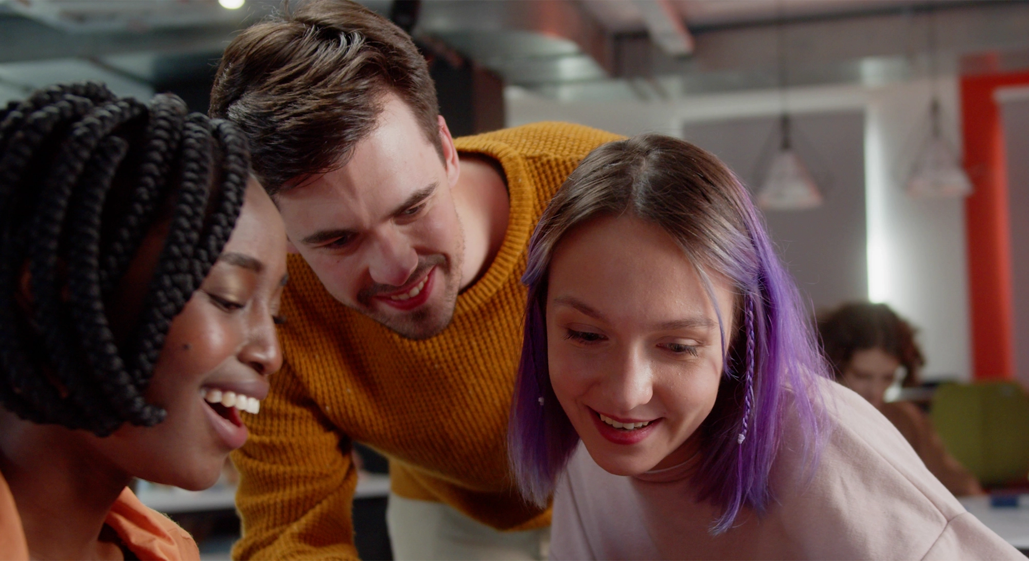 Giovani professionisti osservano con entusiasmo uno smartphone