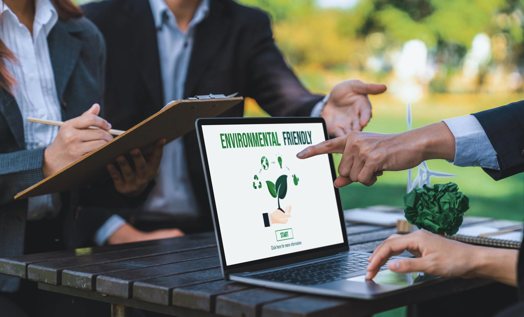 Team aziendale discute strategie di sostenibilità durante un meeting all'aperto