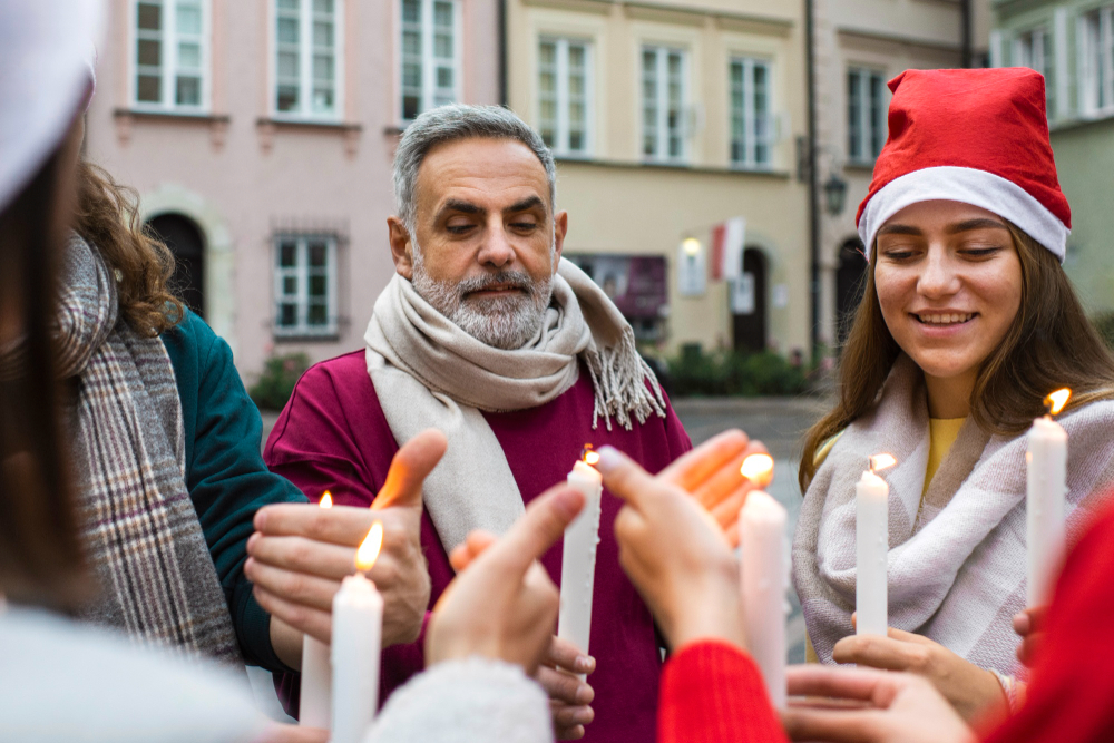 Persone durante una processione serale con candele accese in festa patronale
