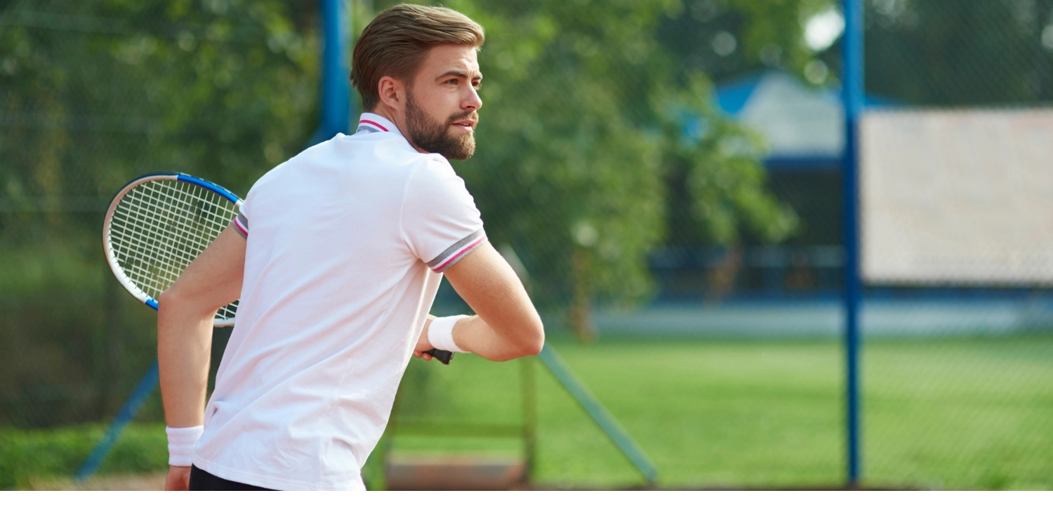 Giocatore di tennis con polo personalizzata bianca in cotone piqué, ideale per sport di racchetta eleganti e performanti