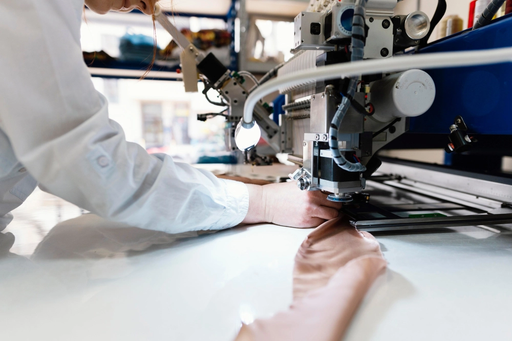 Macchina da ricamo industriale cuce un design personalizzato su tessuto con filo colorato